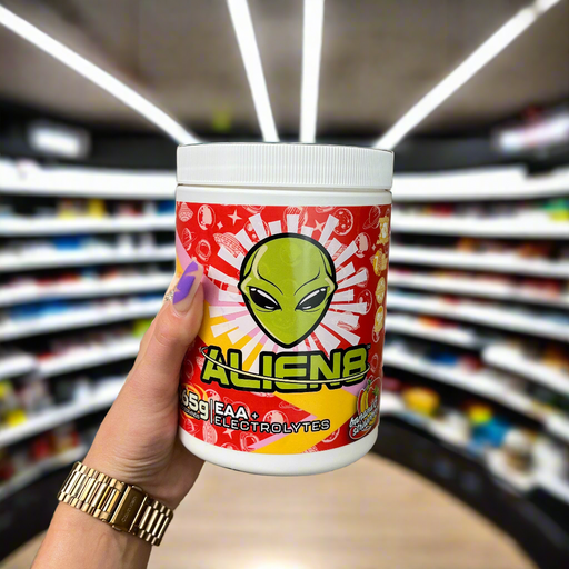 Close-up of (Alien8 EAA + Electrolytes 465g) held up inside My Supplement Shop, clearly showing the front label in a Sports Nutrition setting.