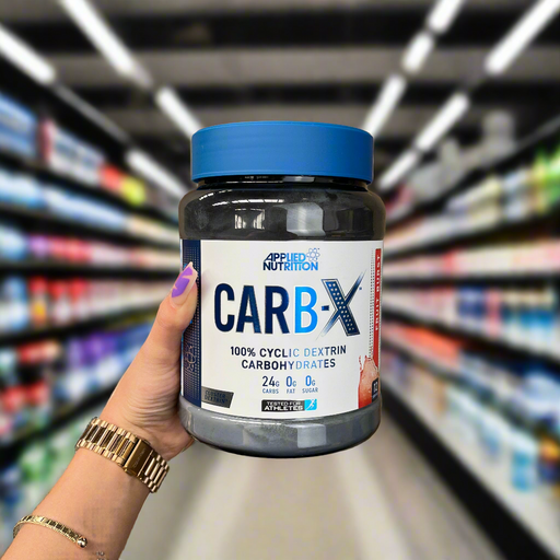 Close-up of (Applied Nutrition Carb X 300g) held up inside My Supplement Shop, clearly showing the front label in a Sports Nutrition setting.