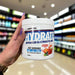 Close-up of (Per4m Hydration Electrolyte Mix 30 Servings) held up inside My Supplement Shop, clearly showing the front label in a Sports Nutrition setting.